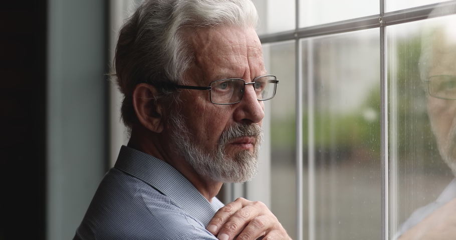 Frustrated middle aged 60s retired man taking off eyeglasses, looking in distance out of window, thinking of personal problems, suffering from loneliness or negative thoughts indoors, ageing concept. | Shutterstock HD Video #1071403489