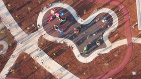 Playground for kids in a park bustling with activity, busy with children having fun and playing on merry-go-round, slide, playhouse and swing, enjoying sunny afternoon casting long shadows. Top view. - Powered by Shutterstock - Get 15% off with code: PIKWIZARD15