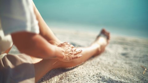 A female model is sunbathing on the white beach of the tropical sea sitting down on the sand. Girl woman summer holiday stunning people seaside lie majestic beauty idyllic tropics Maldive stylish elegant.