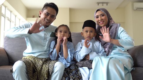 Eid Mubarak celebration moment, Malay family wearing traditional cloth looking at the camera