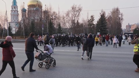 Russia, Omsk, April, 2021: Policemen group walk city street. Police officers row march riot. Special forces team men go. Cops helmet mask head.