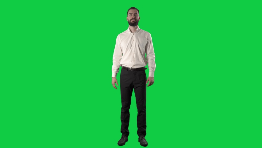 Friendly happy business man waving hand greeting and introducing himself. Full length on green screen chroma key background Royalty-Free Stock Footage #1071410749
