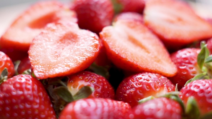 Red Raspberry Juicy Strawberries and Strawberry Halves, Close-up. Delicious Summer Berries. Background of Strawberry Slices and Fresh-Harvest Strawberries. Natural Healthy Vegan Food.