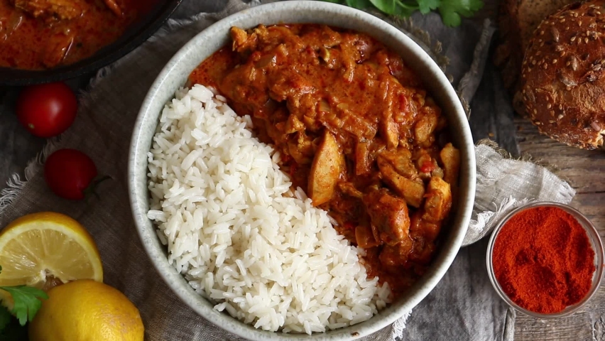 Traditional curry and ingredients. Tikka Masala chicken and rice. Indian food. Top view. Copy space. Wooden background. Royalty-Free Stock Footage #1071413047