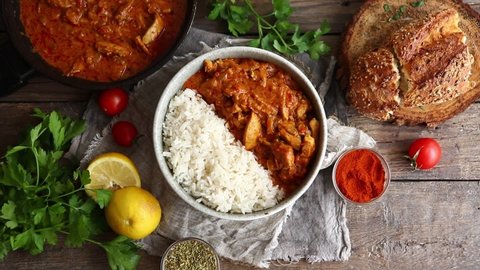 Traditional curry and ingredients. Tikka Masala chicken and rice. Indian food. Top view. Copy space. Wooden background.