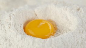 egg falls into flour. eggs in pile of flour close up. a bunch of flour with raw eggs. frame moves forward. 4K UHD video