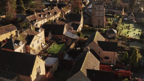 Aerial drone video of a Cotswolds Village Church, a rural scene in English countryside with houses, property and real estate in the UK housing market, Bourton on the Hill, Gloucestershire, England