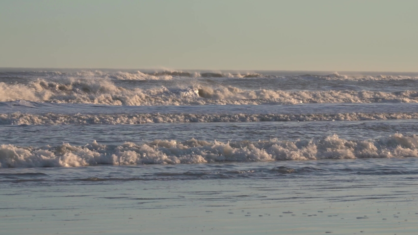 Series Of Ocean Waves Washing Up On Sandy Shore Of Beach During Golden Hour. - wide static