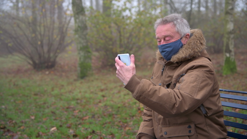 Senior man waves to friends and family during video call