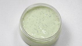 Beautician picks up cream with spatula. Top view. Beauty procedure in modern salon. skincare treatment in cosmetology clinic. Scrubbing or moisturizing skin. Natural cream from jar. 4 k video