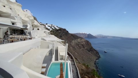 Oia, Greece - September 16 2020: Panoramic view over the Santorini Caldera from the cliffside Mystique, a luxury collection hotel
