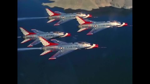 CIRCA 1950s - Supersonic jets fly in formation over water and mountainous terrain in 1959.