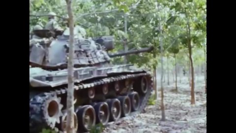 CIRCA 1960s - American army tanks knock over rubber trees in Vietnam as they advance in 1968.