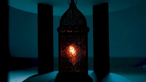 Traditional Engraved decorational arabic or morroccan lanterm glowing on a cement wall background. Ramadan kareem concept.ramadan mubarak . eid mubarak 2021