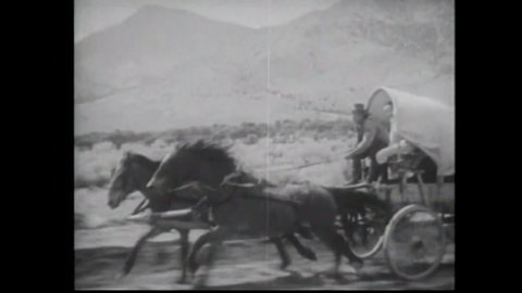 CIRCA 1934 - In this western film, a violent posse on horseback pursues a covered wagon.