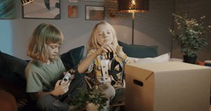 Two little boys putting virtual reality glasses in box after playing at home, funny brothers children finish playing gadget and going to sleep, childhood, having fun during coronavirus isolation. 