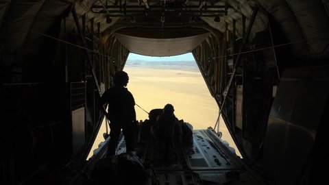 CIRCA 2020 - U.S. Air Force crewmen drop parachute bundles over the desert from a C-130J Super Hercules, East Africa.