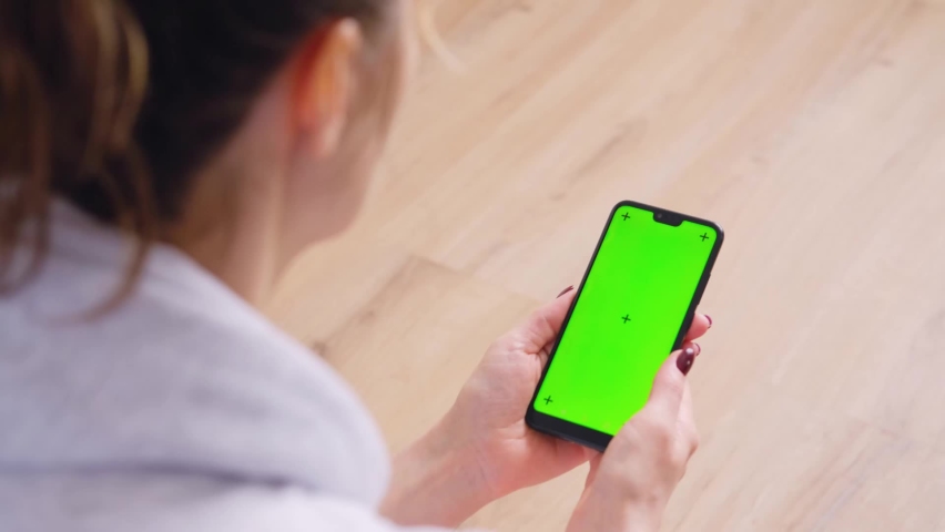 Young Female Using Smart Phone Sitting On Sofa At Home.