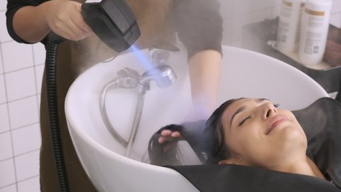 Hairdressers use steam to dry their hair after washing their clients' hair,slow motion shot.