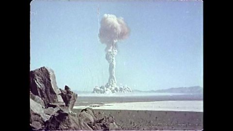 CIRCA 1951 - A mushroom cloud bursts at an atomic bomb testing site in the desert.