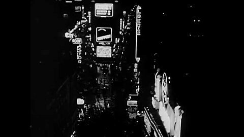 CIRCA 1949 - Times Square is lit up with neon lights at night in New York City.