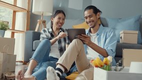 Happy asian young attractive couple man and woman use tablet online shopping furniture decorate house with carton package move in new house. Young married asian moving home shopper online concept. - Powered by Shutterstock - Get 15% off with code: PIKWIZARD15