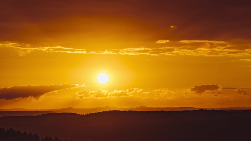 A timelapse of the beautiful sun setting down surrounded with the beautiful orange horizon in 4K