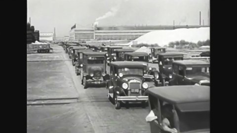 CIRCA 1920s - Ford cars are driven out of a manufacturing plant.