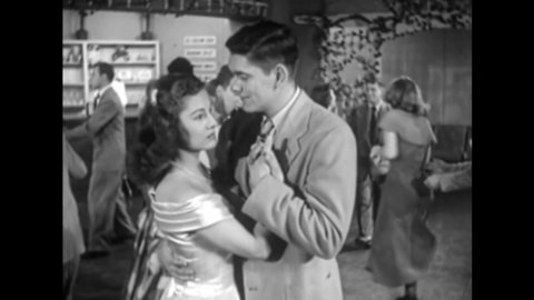 CIRCA 1950 - A teenage boy tries to get a girl to ditch her date at a dance for him.
