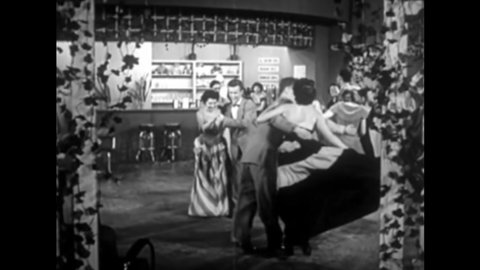 CIRCA 1950 - A teenage boy convinces a girl to leave a dance for a little fun with him.