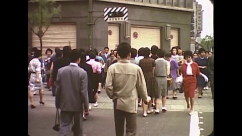 CIRCA 1963 - People maneuver the busy, modern sidewalks of Tokyo, Japan.