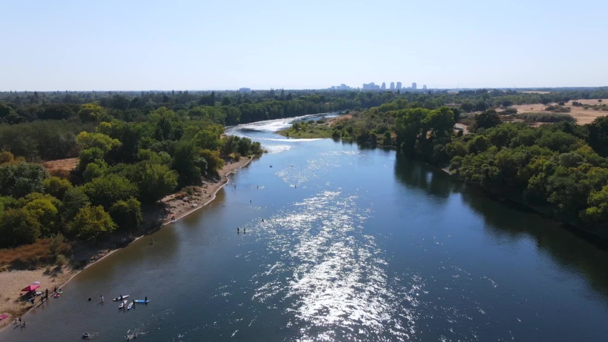 SACRAMENTO, CALIFORNIA - CIRCA 2020 - An excellent aerial shot of people boarding personal watercrafts on the American River in Sacramento. Royalty-Free Stock Footage #1071457675