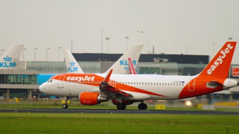 AMSTERDAM, THE NETHERLANDS - JULY 27, 2017: EasyJet Airbus A320 G-EZOO accelerate before departure at runway. Schiphol Airport, Amsterdam, Holland