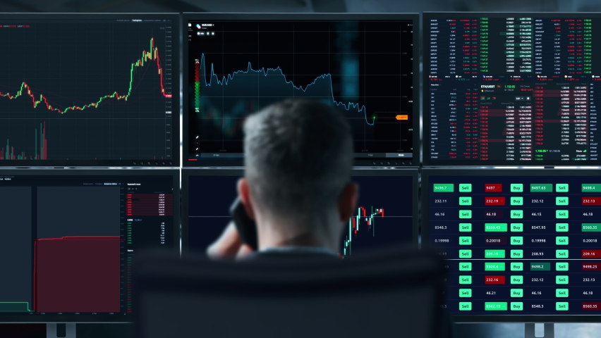 Trader is working with multiple computer screens full of charts and data analysis and stock broker trading online. Back view. Concept of bitcoin and stock market trading. Royalty-Free Stock Footage #1071462898