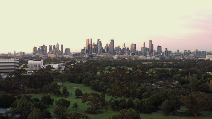 Peacefully pink silhouetted Cityscape aerial of Melbourne with gorgeous colours revealing golf course below