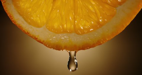Water dropping from yellow pulp of fresh citrus fruit. Close up orange slice rich in vitamin c used for detoxification drinks 4k footage