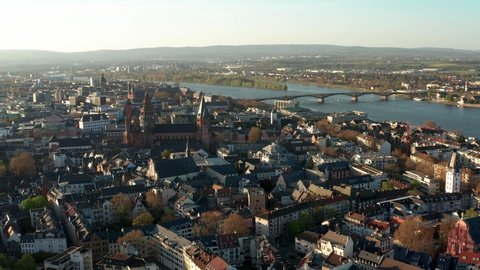 Drone aerial circle around the Cathedral church of Mainz on a warm spring day with the blue Rhine river in the back