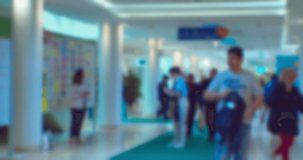 Business theme background. Unrecognizable people in a large and bright business center. Blurry defocused video.