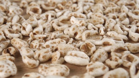Puffed spelt wheat close up. Uncooked cereal flakes. Macro. Dolly shot