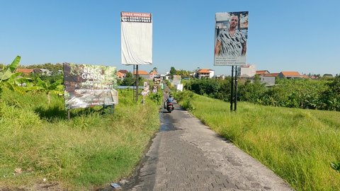 Canggu, Indonesia - April 24 2021: Point of view footage of a moto that drive on the shortcut road that links Canggu and the Batu Belig road near Seminyak in Bali, Indonesia. 