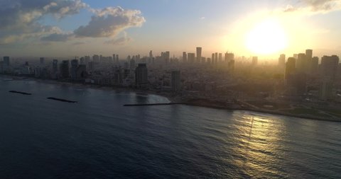 4k drone shot of the Tel Aviv-Yafo skyline at dawn, aerial view of a big city in Israel in the Middle East on a sunny morning, beautiful sunrise, skyscrapers, Mediterranean Sea in the foreground
