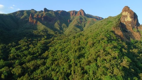 Flying over the cliffs and treetops of african rainforest in colorful evening light. Aerial video, remnants of wild African nature in Harenna forest, Bale Mountains National Park in Ethiopia.