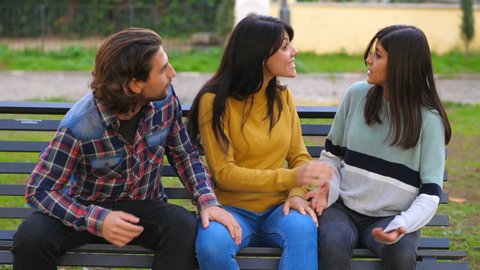 female complicity - young man is excluded from the conversation by two friends