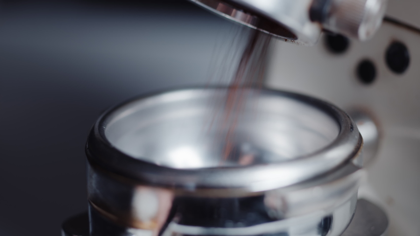 Professional barista worker use grinder machine to grind fresh coffee beans for make hot beverage at coffee cafe shop. Extreme macro close up Royalty-Free Stock Footage #1071524248