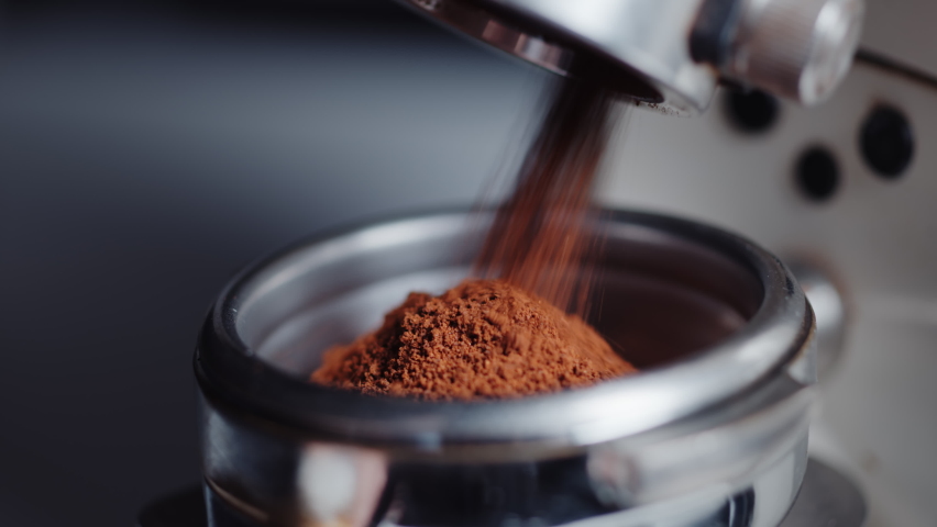 Professional barista worker use grinder machine to grind fresh coffee beans for make hot beverage at coffee cafe shop. Extreme macro close up | Shutterstock HD Video #1071524248