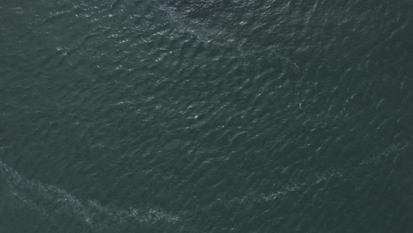 Top down view fly by of people walking around The Poolbeg Lighthouse.