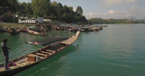 Khao Sok , Thailand - 02 08 2019: Aerial View of Traditional Long Tail Boat and Male on Rudder in Exotic Tropical Lagoon in Thai Countryside