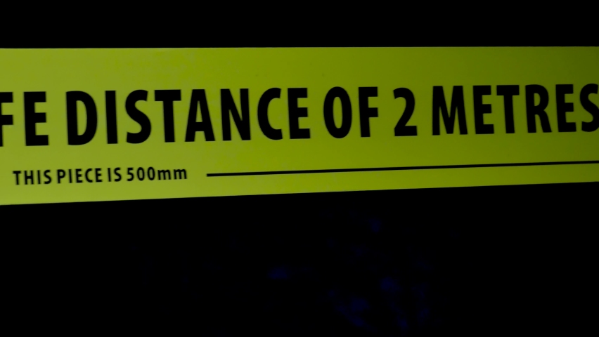 A shot of a yellow social distance band against a black background