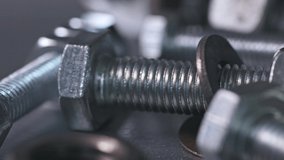 Slider shot video of metal chrome bolts and nuts in a chaotic order. Background concept for fasteners and construction topics. Repair and spare parts concept