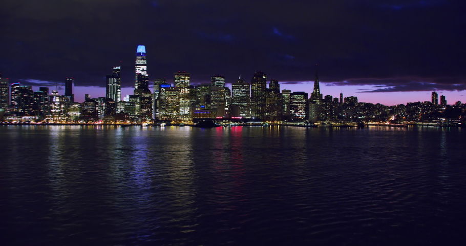 Amazing aerial view of San Francisco skyline. Flyover the Pacific Ocean. Famous skyscrapers over a night  sky. Shot in 8K. California, United States.